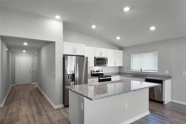 kitchen featuring stainless steel appliances, a center island, sink, and white cabinets