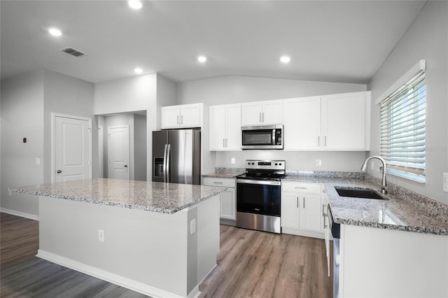 kitchen with sink, white cabinets, a center island, stainless steel appliances, and light stone countertops