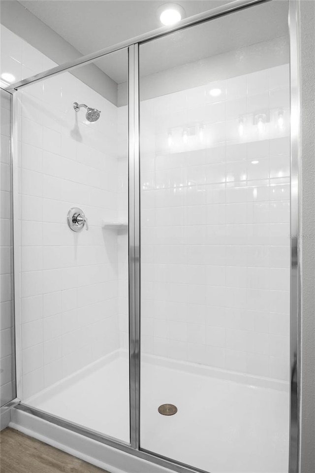 bathroom featuring wood-type flooring and an enclosed shower