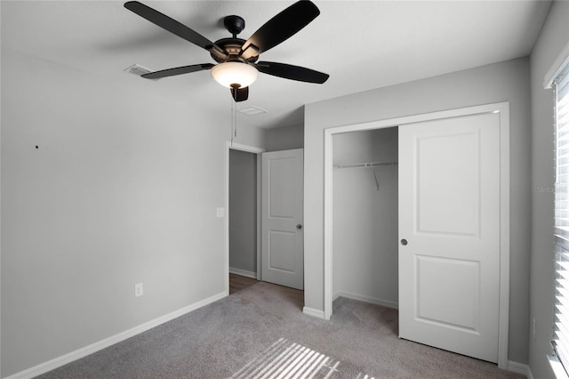 unfurnished bedroom with ceiling fan, light carpet, and a closet