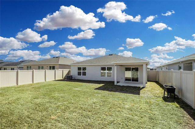 back of house featuring central AC and a lawn