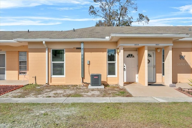 view of front of house featuring central AC and a front lawn