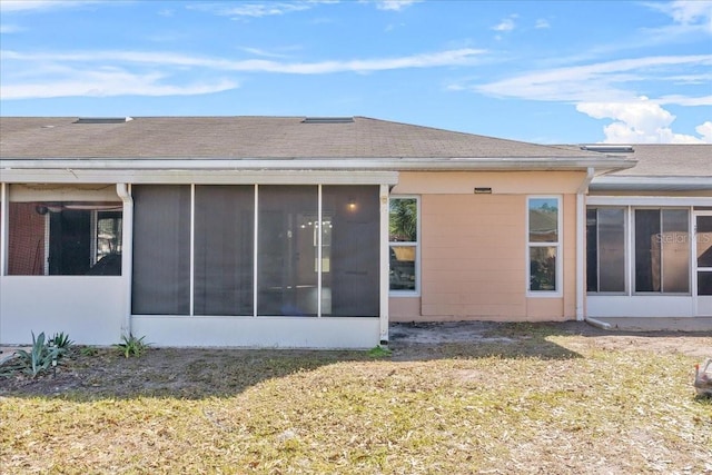 rear view of property featuring a yard and a sunroom