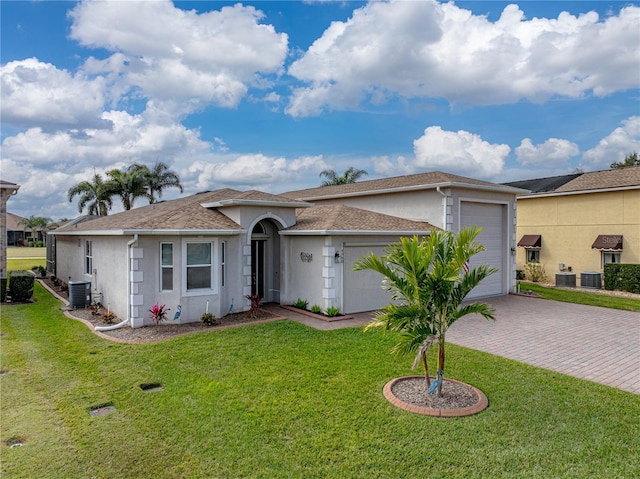 ranch-style home featuring a garage, central AC, and a front lawn