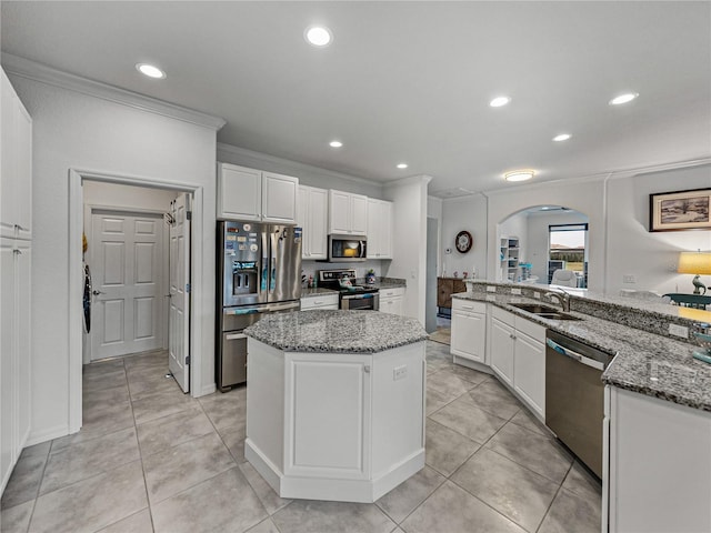 kitchen featuring sink, white cabinetry, stainless steel appliances, light stone counters, and a kitchen island