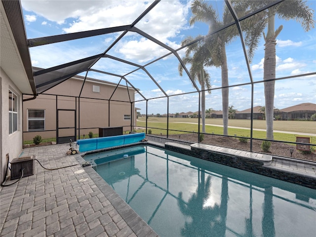 view of pool with central AC unit, a lanai, and a patio