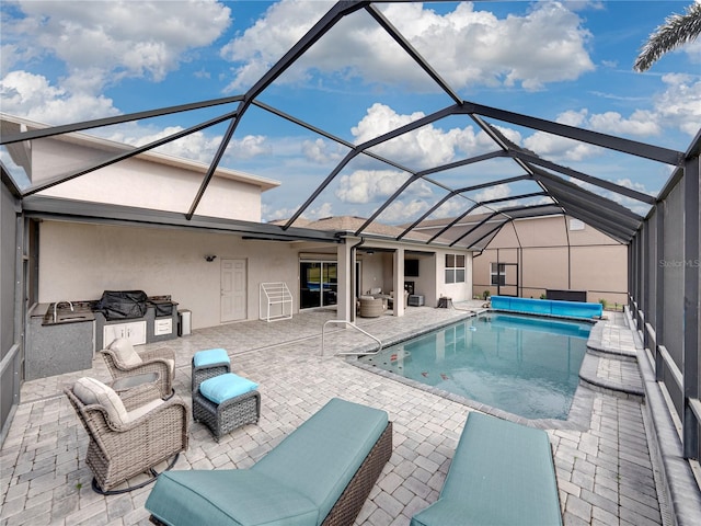 view of pool with a lanai, area for grilling, and a patio area