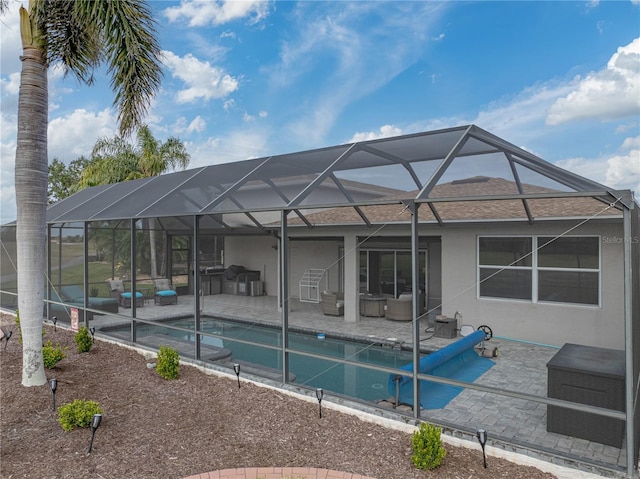 view of swimming pool featuring a patio area, outdoor lounge area, and glass enclosure