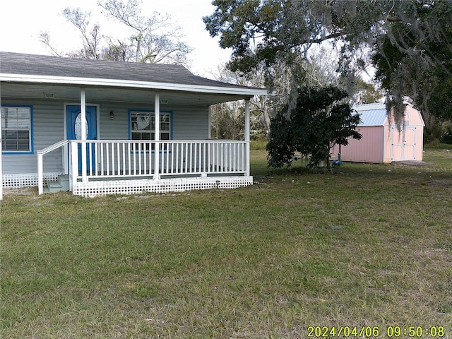 view of front of property featuring a porch, a front lawn, and a storage unit