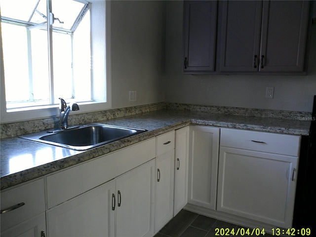 kitchen featuring white cabinetry, sink, and dark tile patterned floors