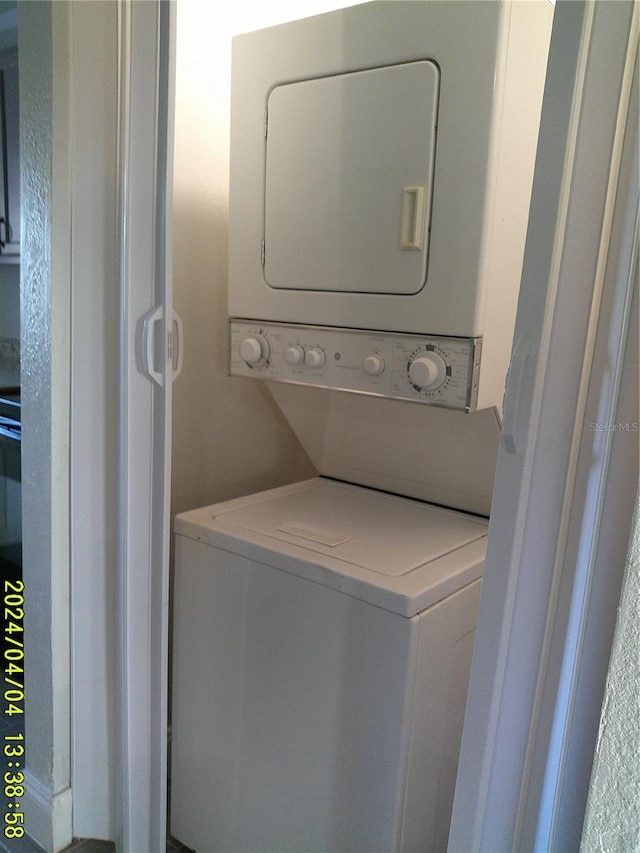 laundry area featuring stacked washer / drying machine