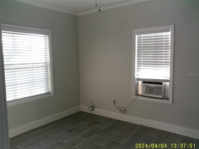 spare room with cooling unit, ornamental molding, and a healthy amount of sunlight