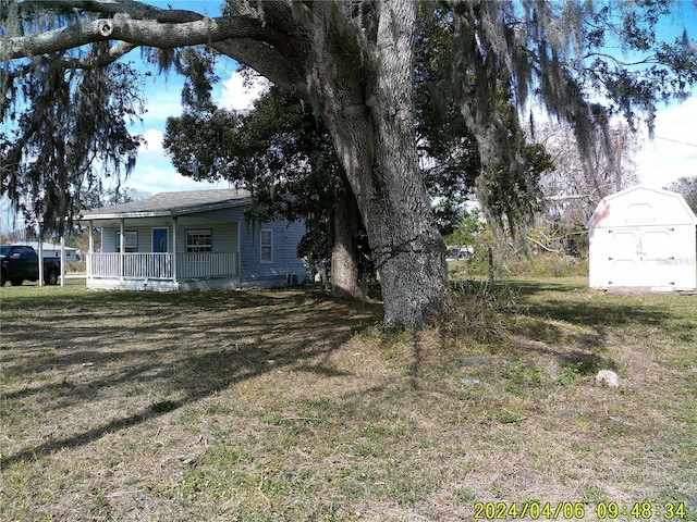 view of yard with a storage shed and covered porch