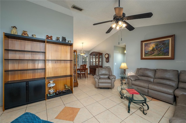 living room featuring lofted ceiling, light tile patterned floors, a textured ceiling, and ceiling fan