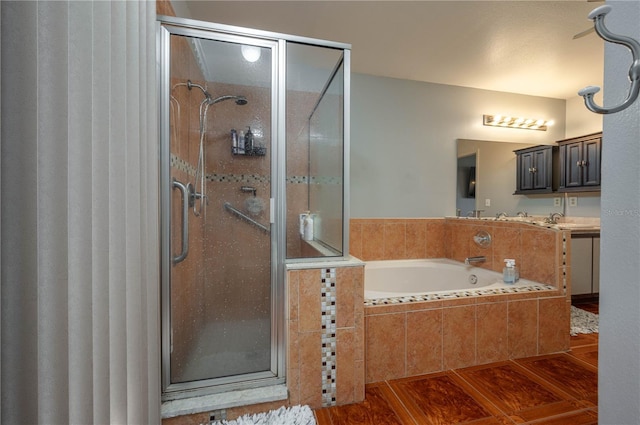 bathroom with wood-type flooring, independent shower and bath, and vanity