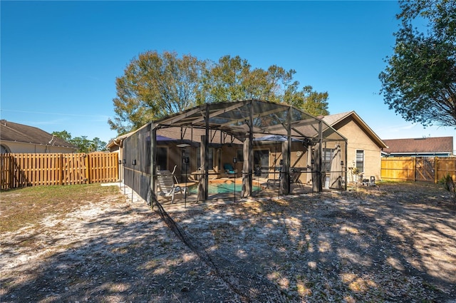 rear view of house featuring a lanai, a patio area, and a swimming pool