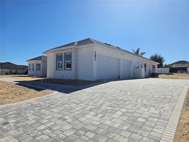 view of front of house featuring a garage and central AC unit