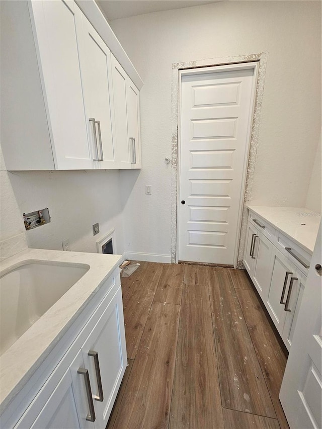 laundry room featuring hookup for a washing machine, hookup for an electric dryer, a sink, cabinet space, and dark wood finished floors