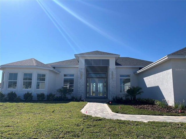 view of front of property with a front yard and french doors