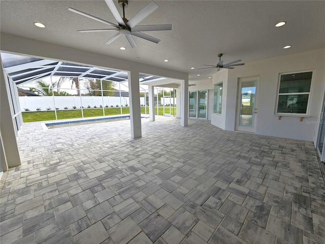 view of patio / terrace with a ceiling fan, glass enclosure, and fence