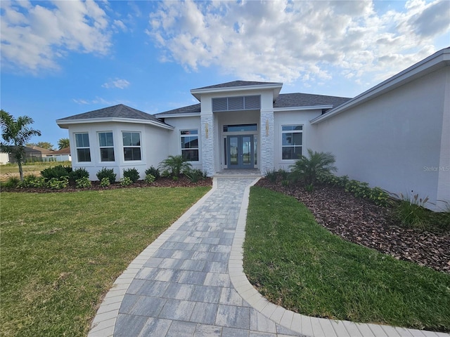 view of front of home featuring french doors, a front yard, and stucco siding