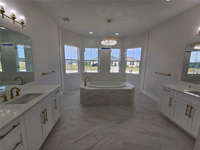 bathroom featuring a bath, marble finish floor, visible vents, and a sink