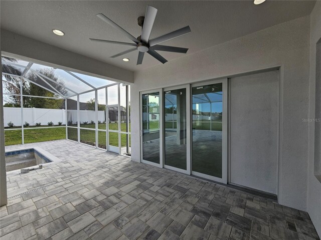 view of patio featuring a lanai, a ceiling fan, and fence