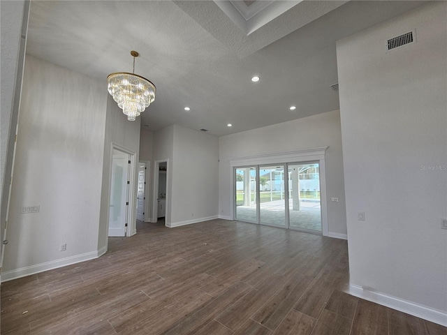 unfurnished living room with dark wood-style floors, visible vents, and baseboards