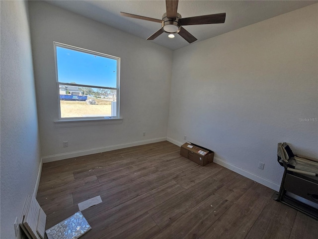 empty room with a ceiling fan, baseboards, and wood finished floors