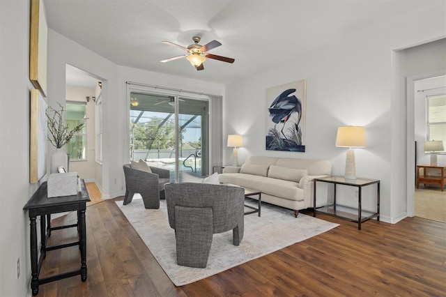 living room with dark hardwood / wood-style floors and ceiling fan