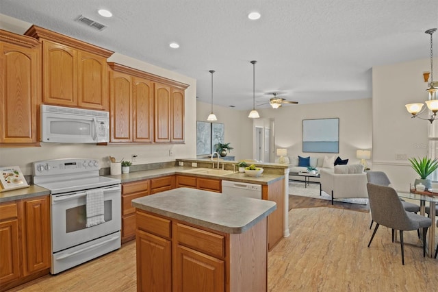 kitchen featuring a kitchen island, pendant lighting, sink, light wood-type flooring, and white appliances