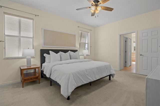 carpeted bedroom with ceiling fan and ensuite bath