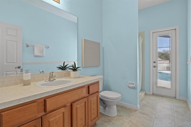 bathroom featuring tile patterned flooring, vanity, curtained shower, and toilet