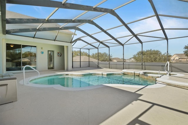 view of pool with an in ground hot tub, glass enclosure, and a patio area