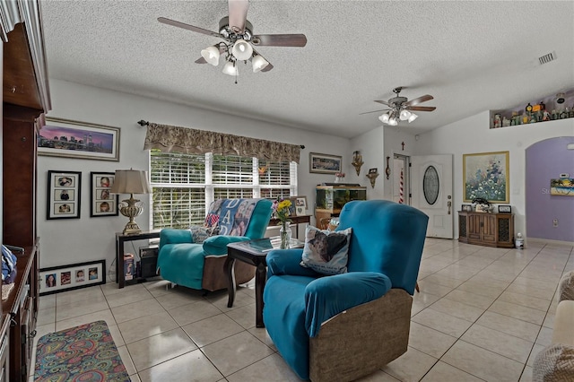 living room featuring lofted ceiling, light tile patterned floors, a textured ceiling, and ceiling fan