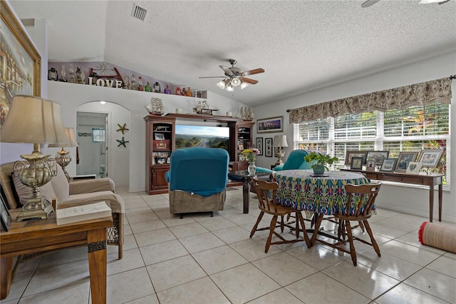 dining room with lofted ceiling, light tile patterned floors, a textured ceiling, and ceiling fan