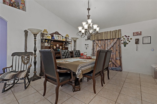 dining room with a notable chandelier, a barn door, vaulted ceiling, and light tile patterned floors