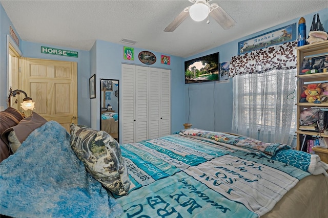 bedroom with a textured ceiling, ceiling fan, and a closet