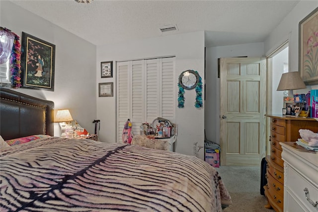 carpeted bedroom with a textured ceiling and a closet