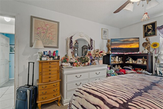 bedroom with light tile patterned floors, a textured ceiling, and ceiling fan