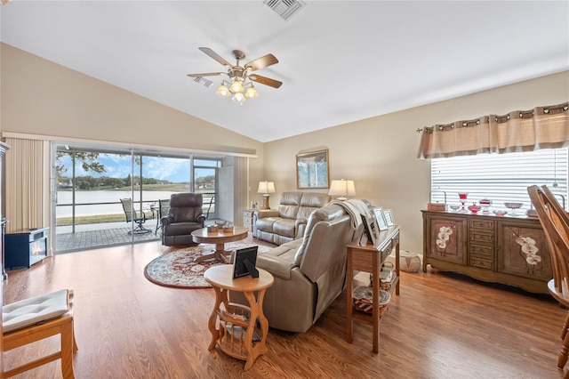 living room featuring vaulted ceiling, wood-type flooring, a water view, and ceiling fan