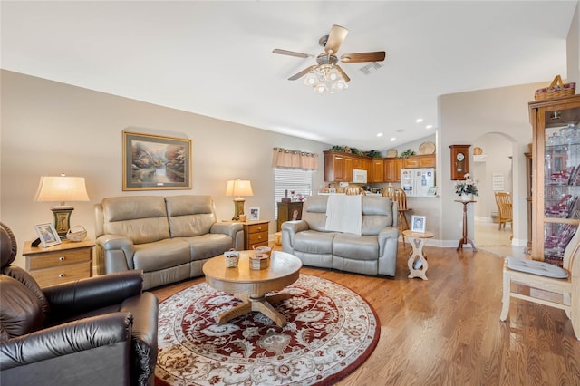 living room featuring lofted ceiling, light hardwood / wood-style flooring, and ceiling fan