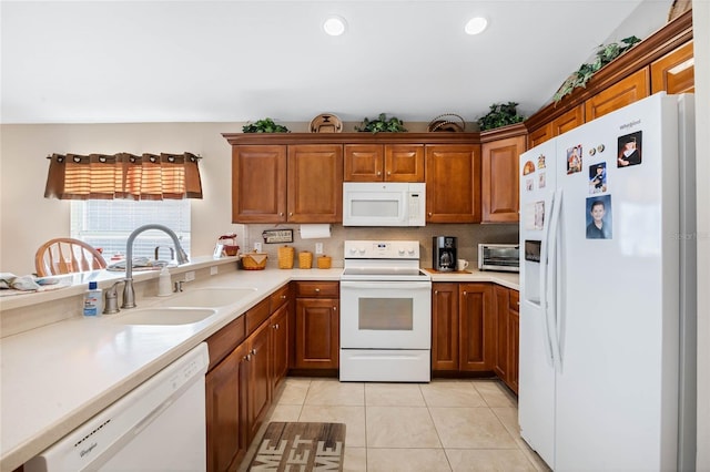 kitchen with tasteful backsplash, light tile patterned flooring, sink, and white appliances