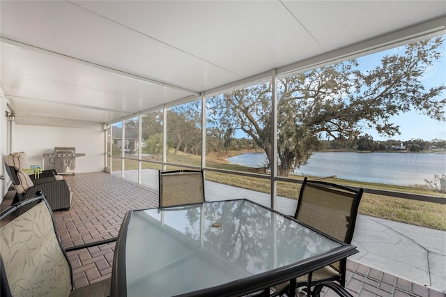 sunroom / solarium featuring a water view