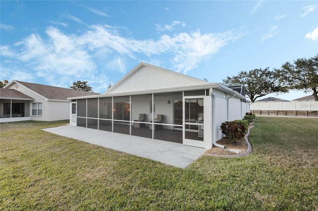 back of property featuring a yard, a patio area, and a sunroom