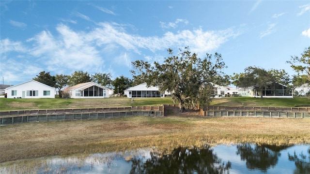 rear view of house featuring a yard and a water view