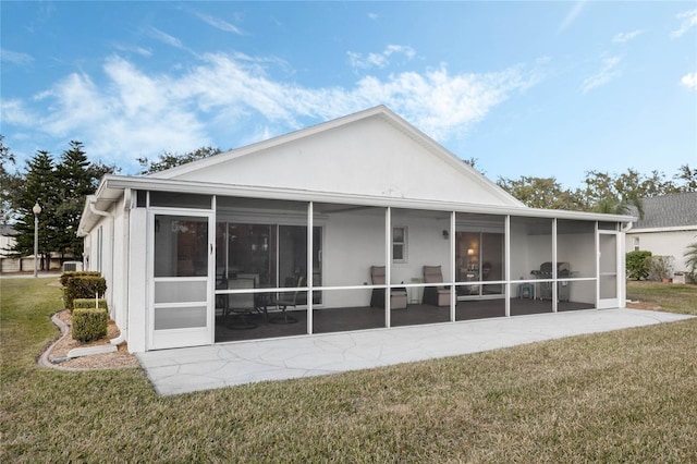 rear view of property with a sunroom and a lawn