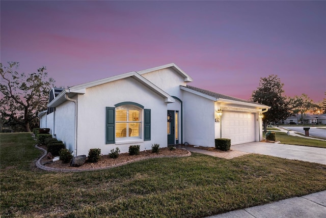 ranch-style house featuring a garage and a lawn