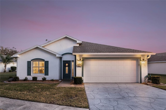 ranch-style house with a garage and a yard