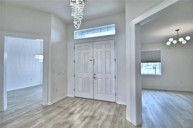 foyer entrance featuring light hardwood / wood-style floors and a notable chandelier